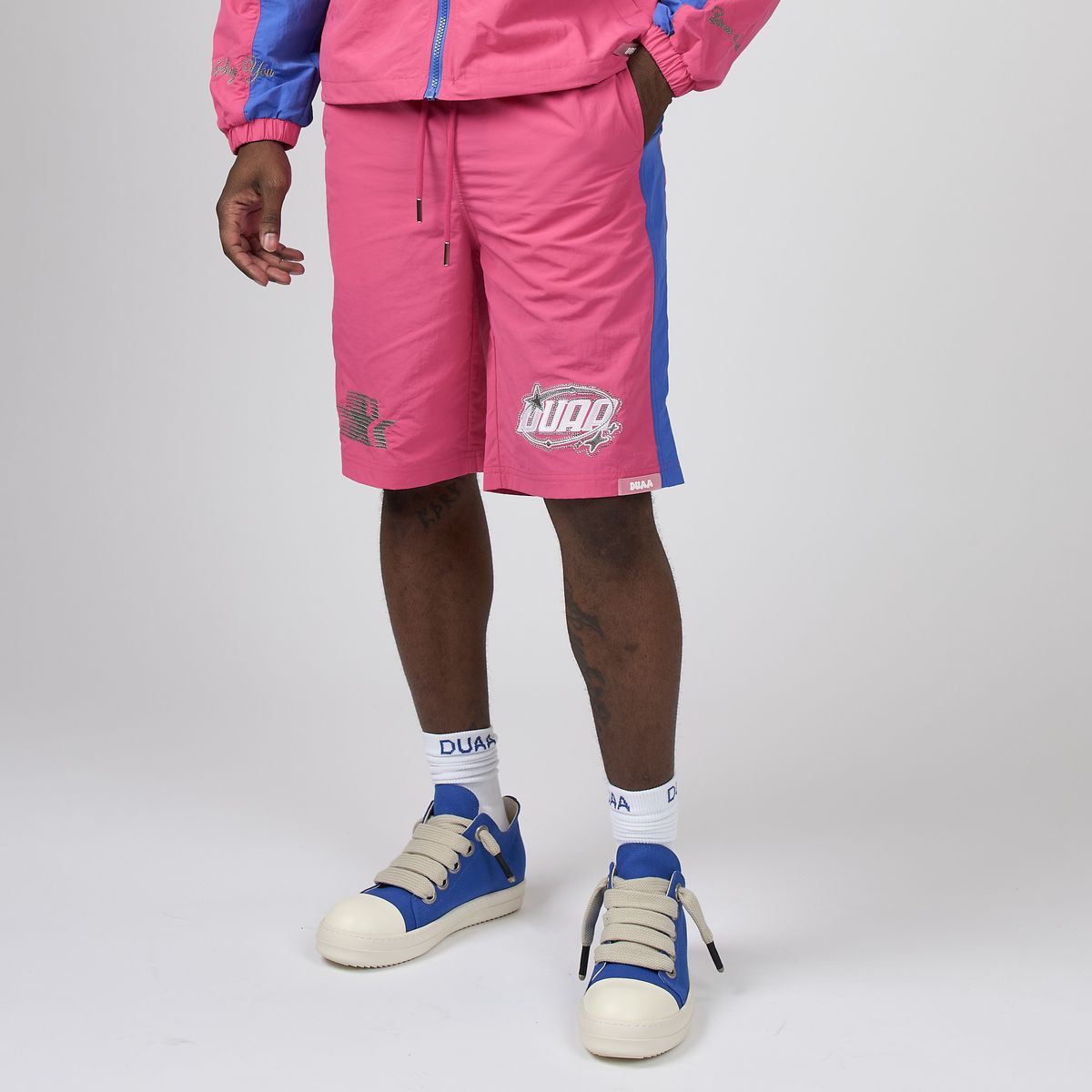 Men's pink sport shorts with blue side panels and DUAA logo