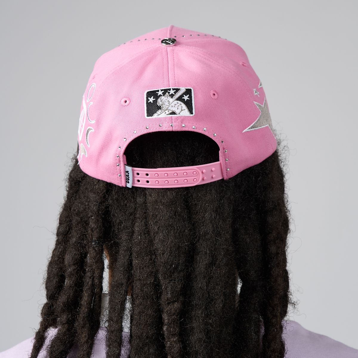 Men's pink DUAA cap back view with black star patch and adjustable strap