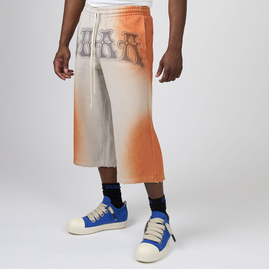 Men's two-tone orange/stone capri jeans with drawstring waist and large front print