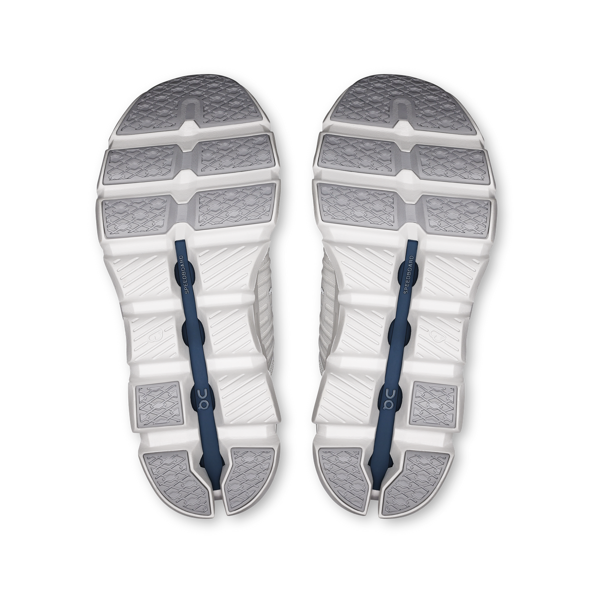 Shoe outsoles in white with textured tread and blue traction inserts