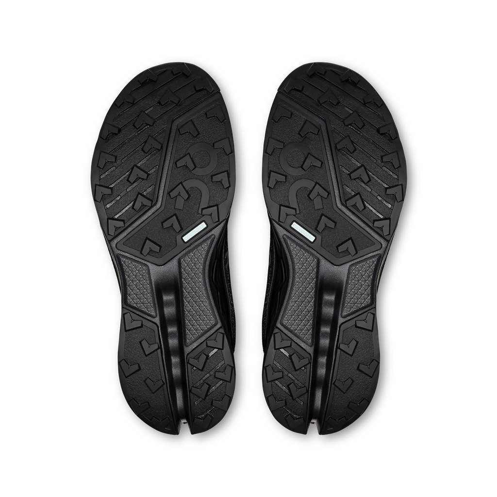 Pair of black shoe outsoles with rugged tread and On branding