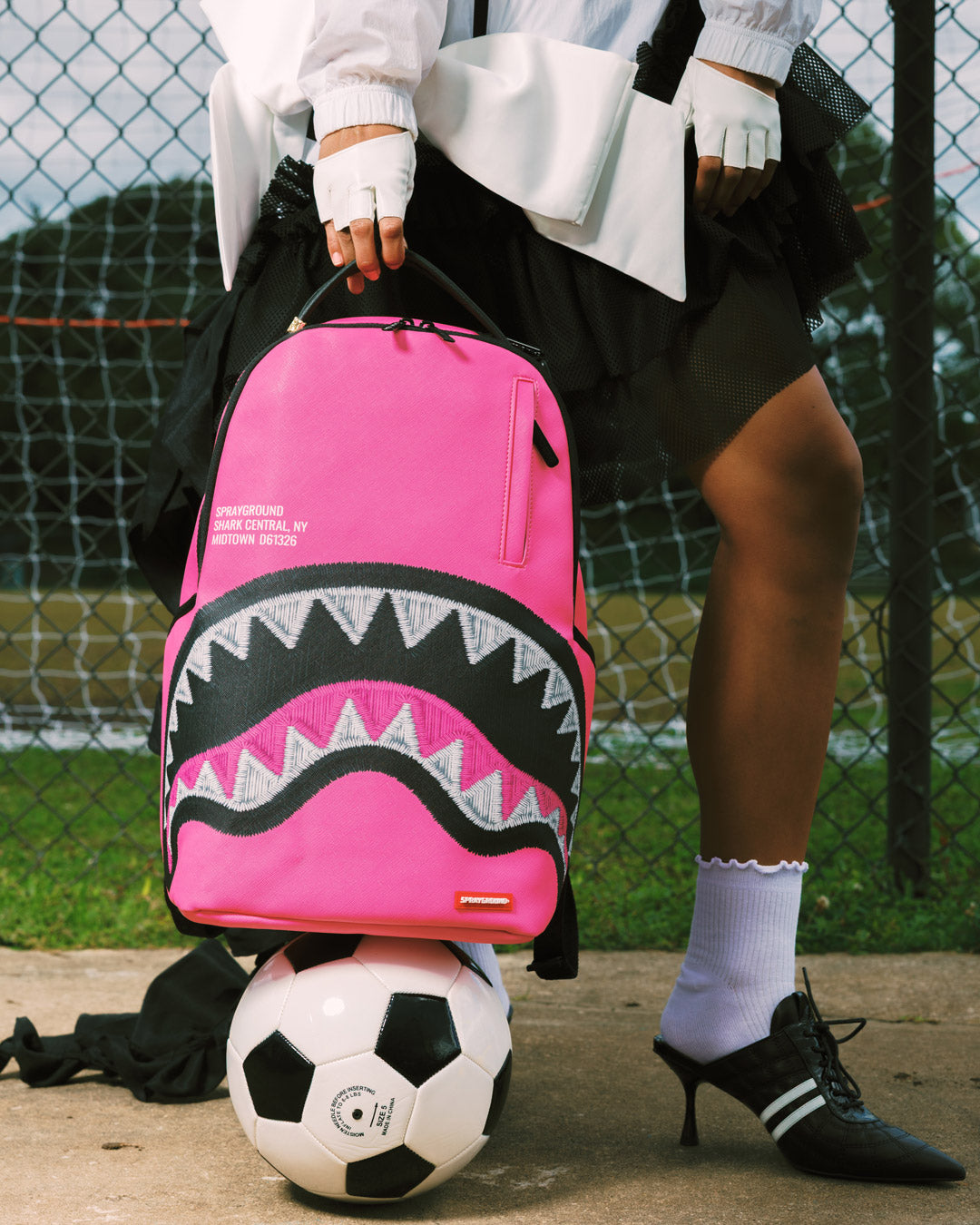 Pink backpack with black zigzag shark graphic front and side pocket