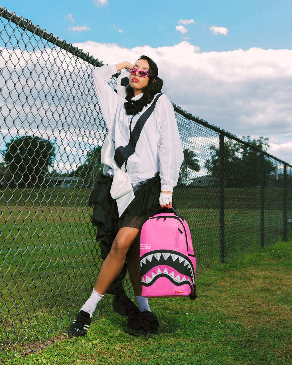 Pink Shark central backpack with black zigzag and shark graphic, carried on shoulder