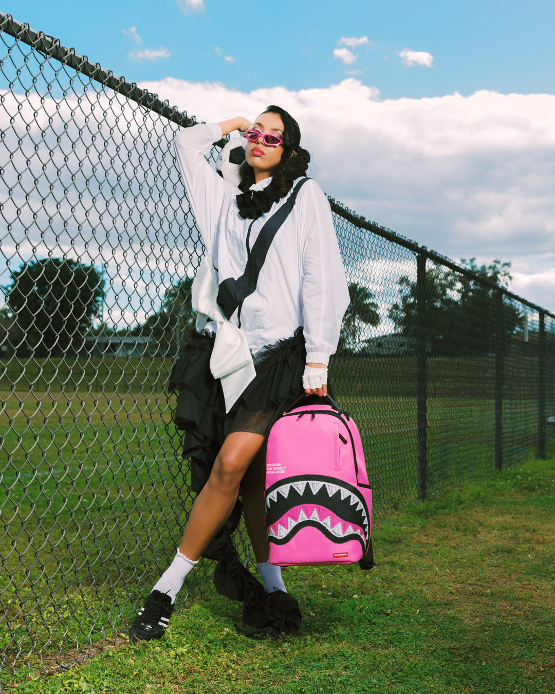 Pink Shark central backpack with black zigzag and shark graphic, carried on shoulder