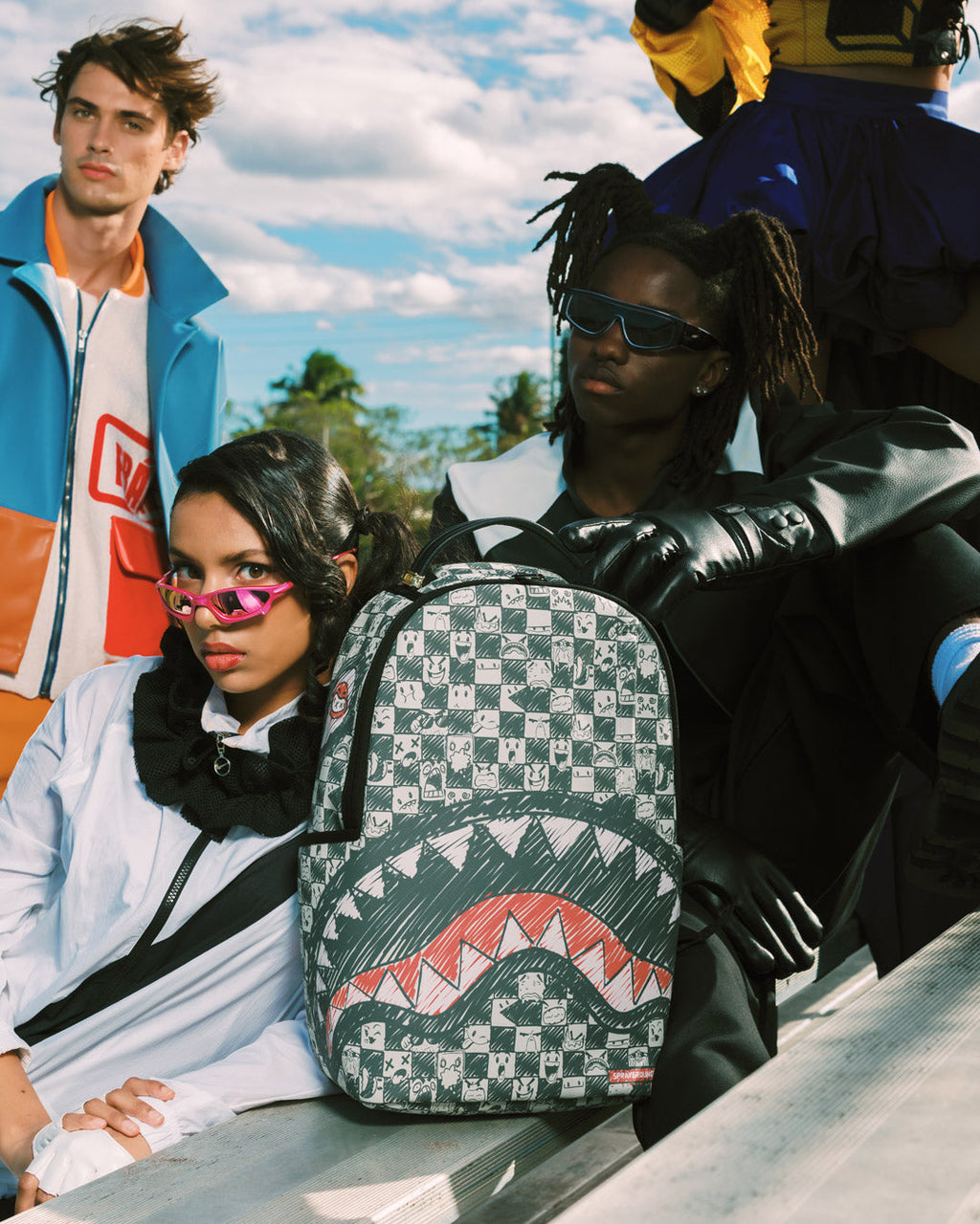 Sprayground backpack with black straps and red shark print on patterned front