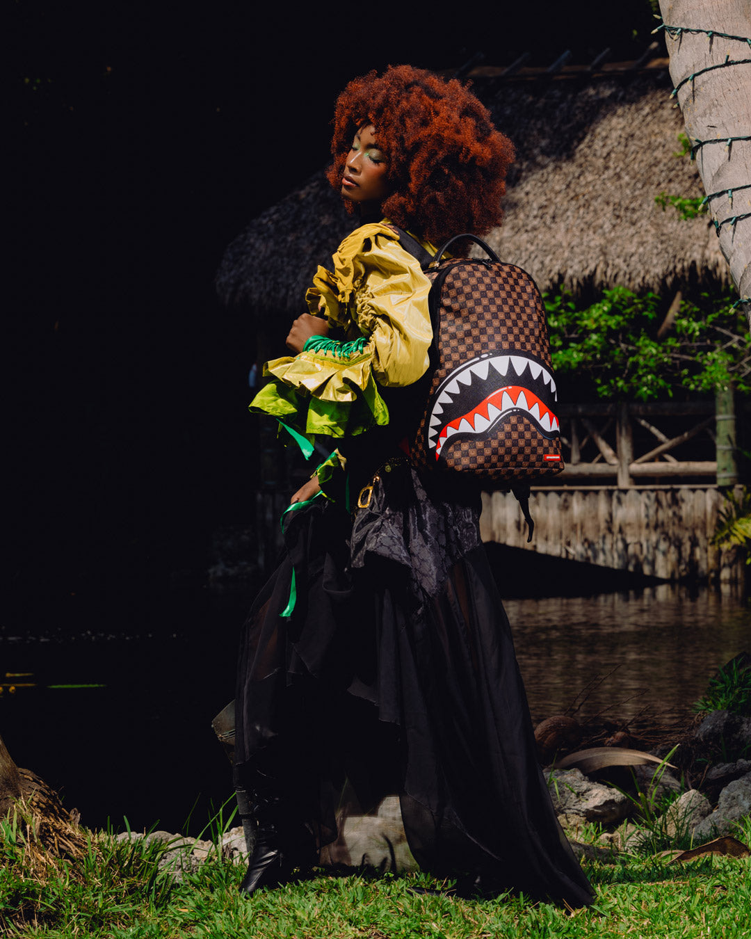 Backpack with shark-mouth graphic carried by a person wearing a bright yellow jacket