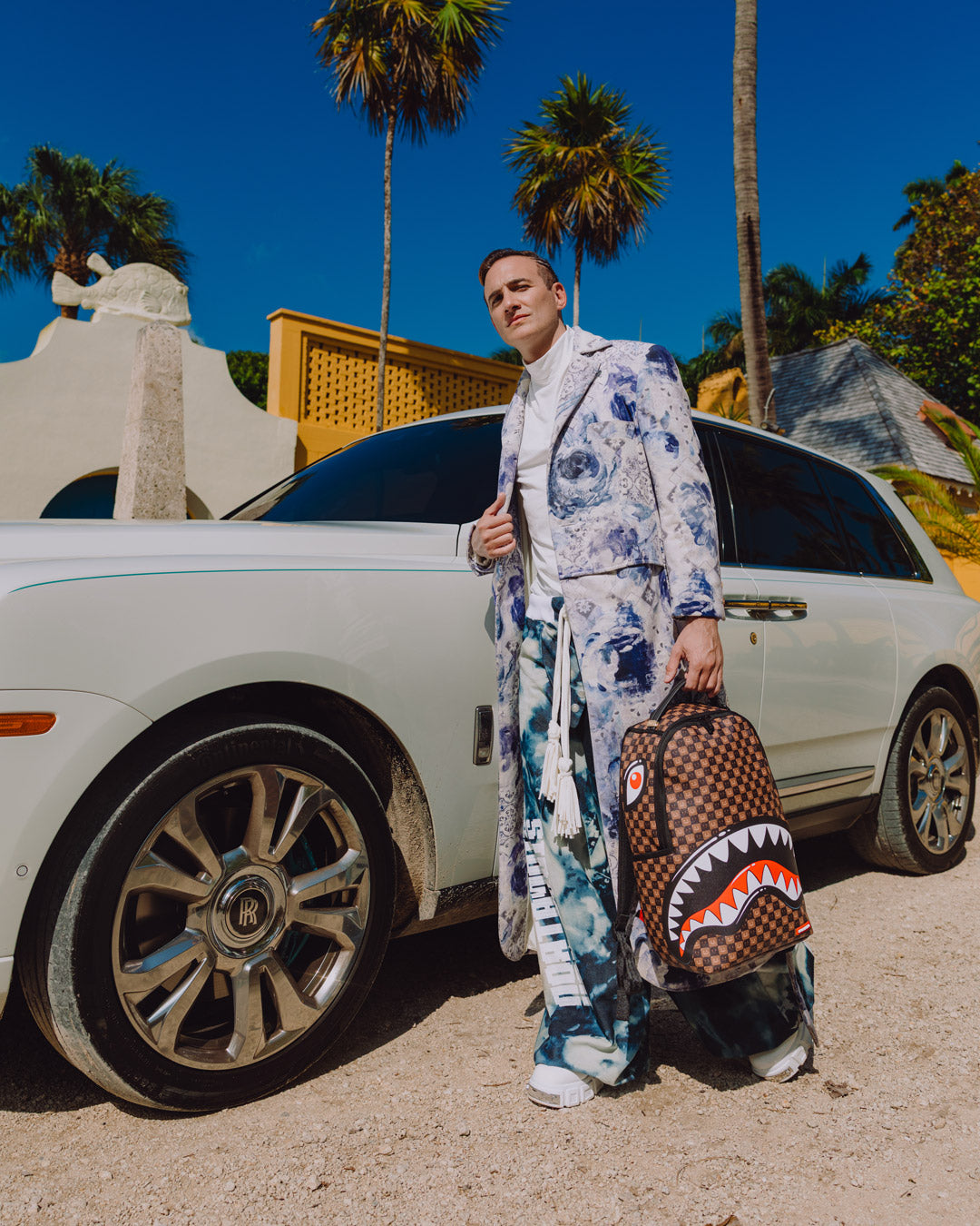 Backpack bag with brown check pattern and white shark-mouth design, carried by person