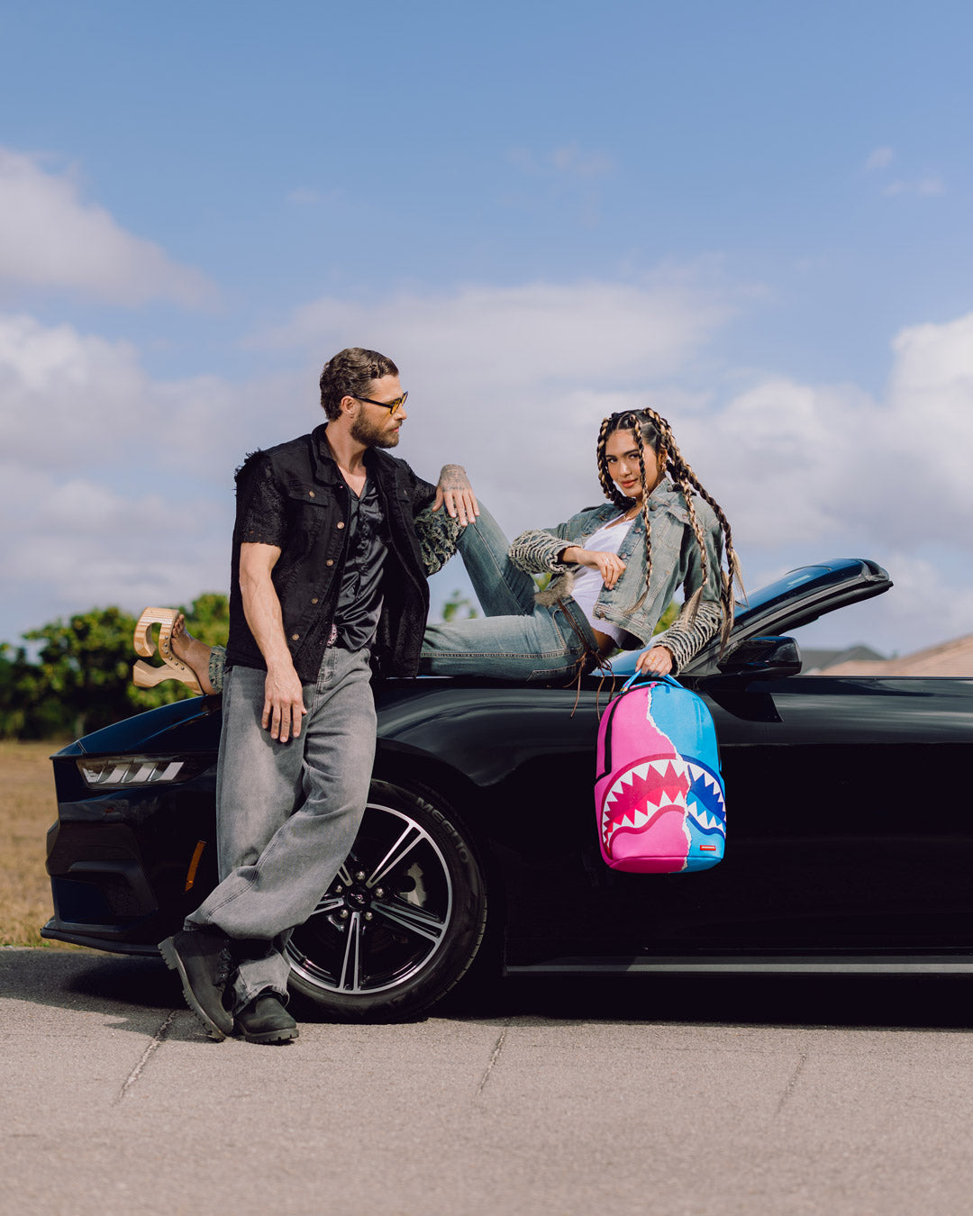 Shark-themed mini backpack on car seat, pink and teal shark face artwork