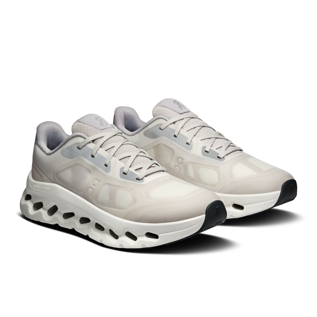 Pair of women's ivory and alloy running shoes with lace-ups and black traction pods