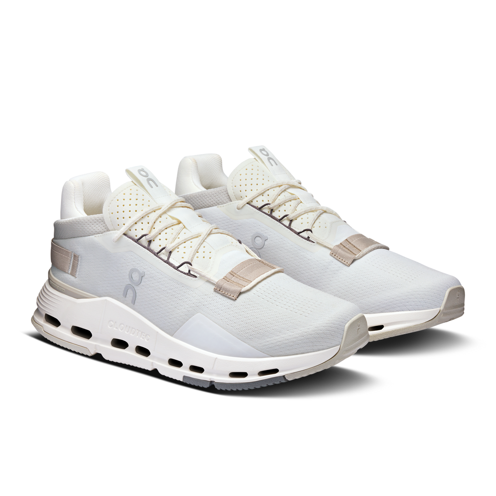 Pair of white lace-up running shoes with sand heel tabs and CloudTec outsole
