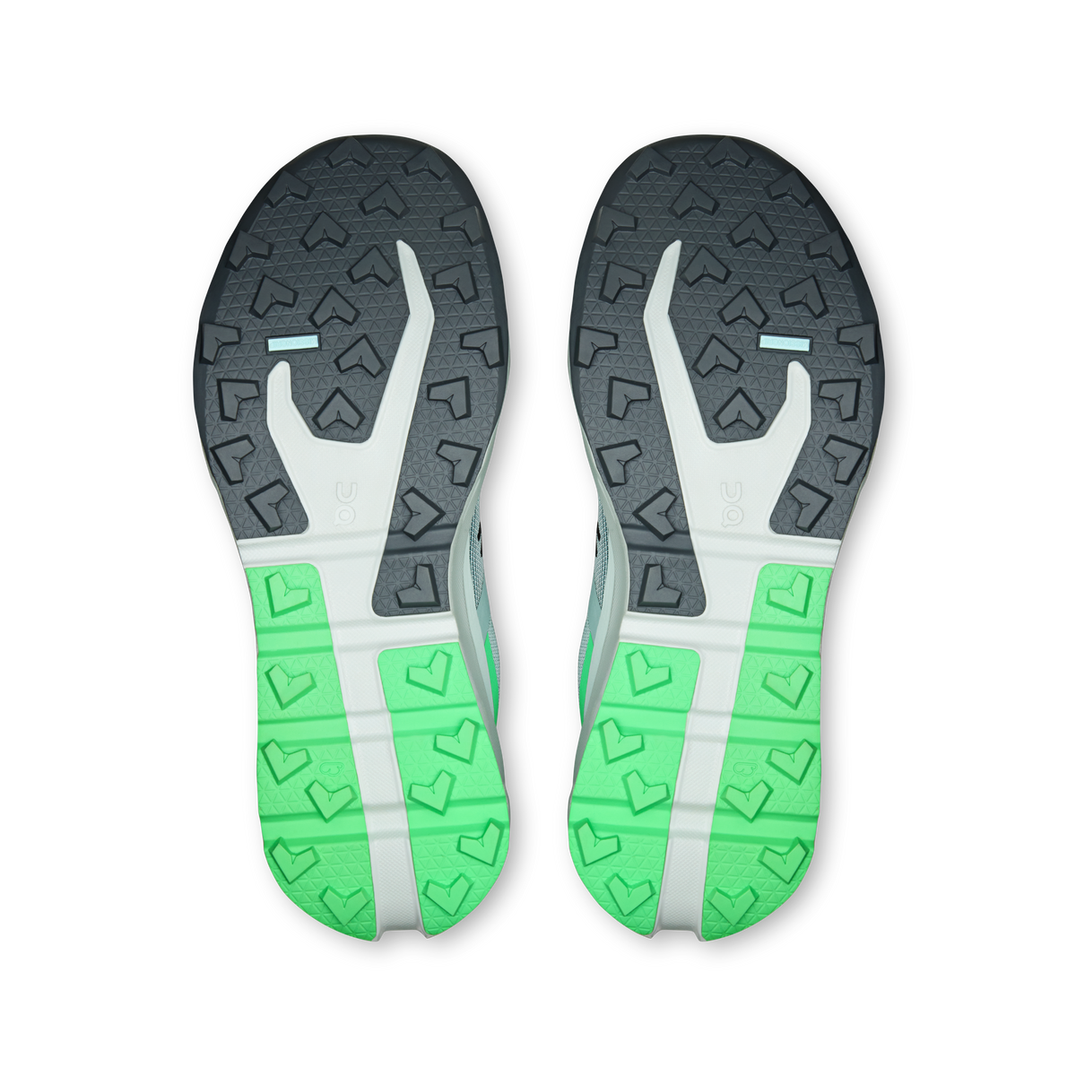 Pair of running shoe outsoles in dark gray with green traction pads