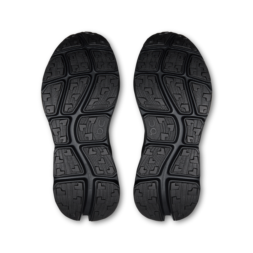 Pair of black shoe outsoles with deep tread and patterned traction blocks