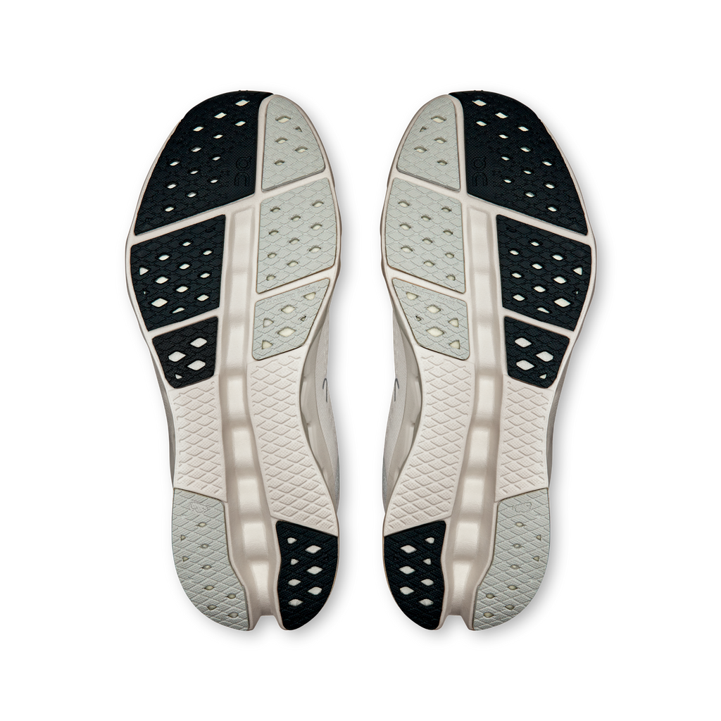 Bottom view of white outsole with dark tread sections and cushioning pods