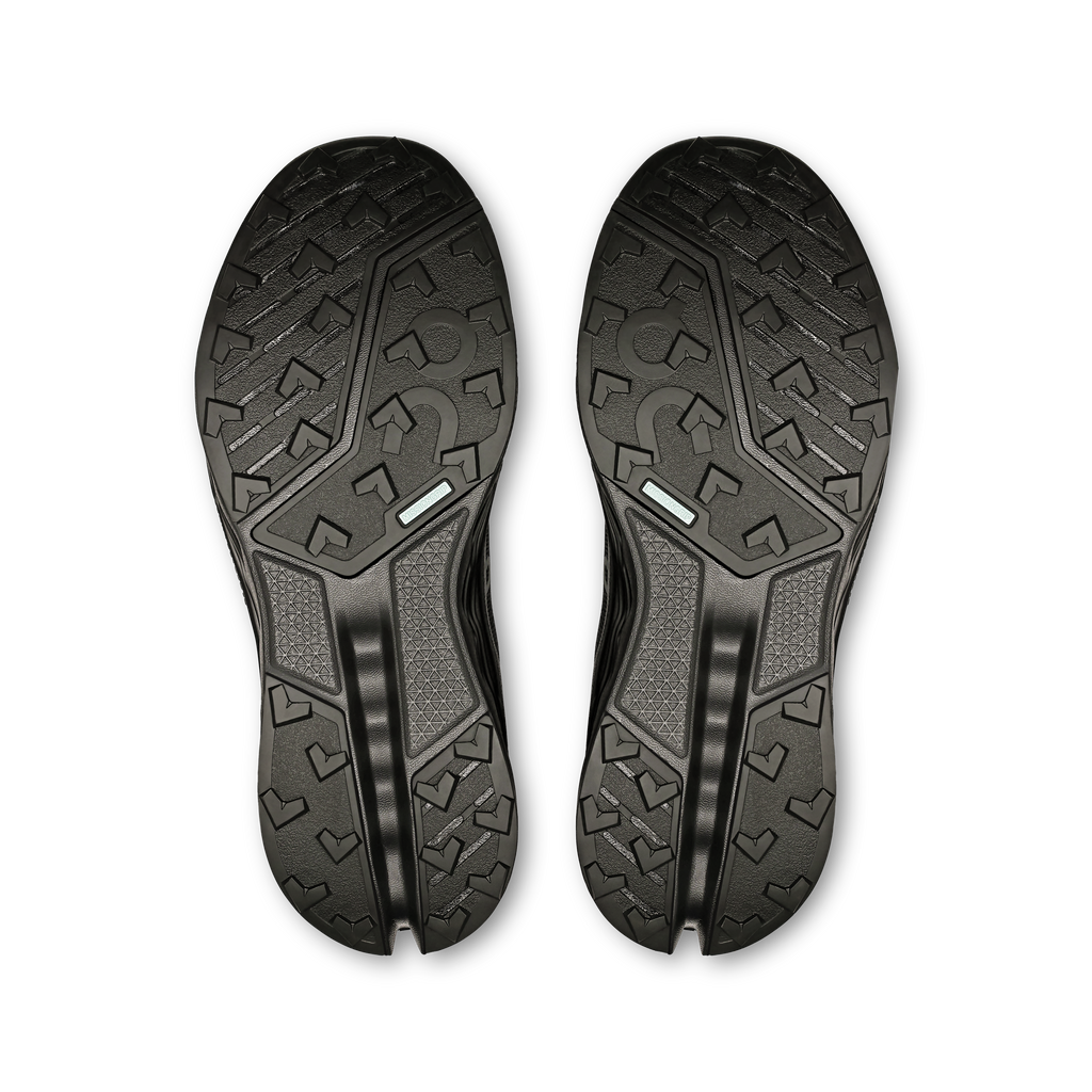 Women’s black trail shoe outsoles, textured tread with curved rubber grooves