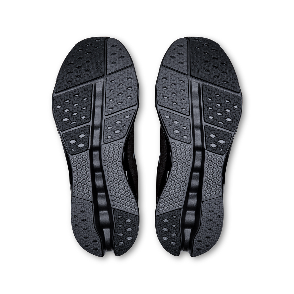 Pair of black shoe outsoles with textured tread and raised grip channels
