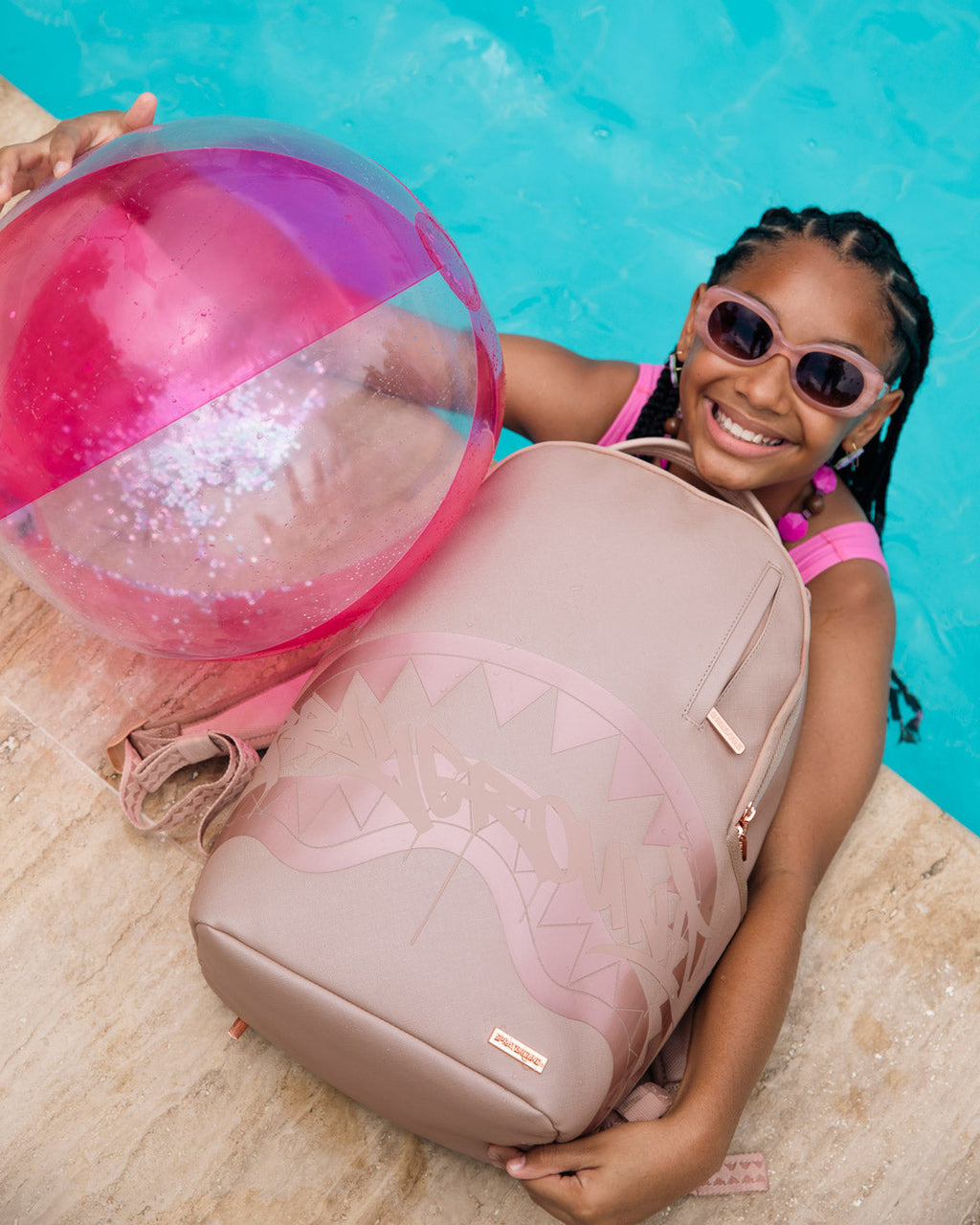 Sprayground rose backpack with shark graphic, front view while held