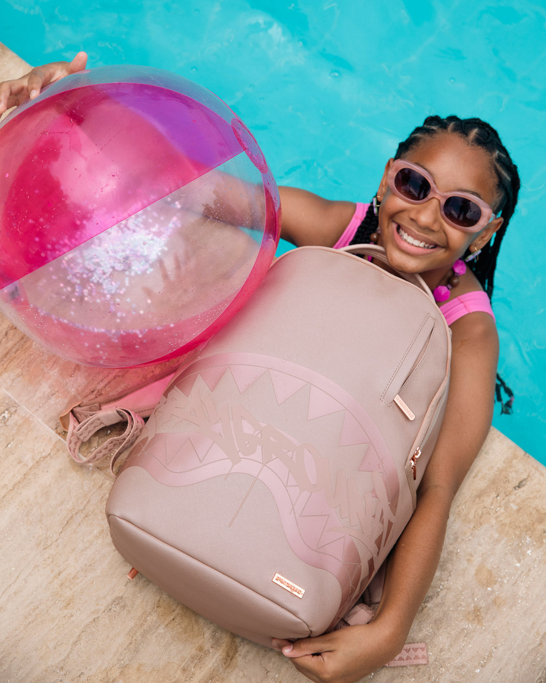 Sprayground rose backpack with shark graphic, front view while held