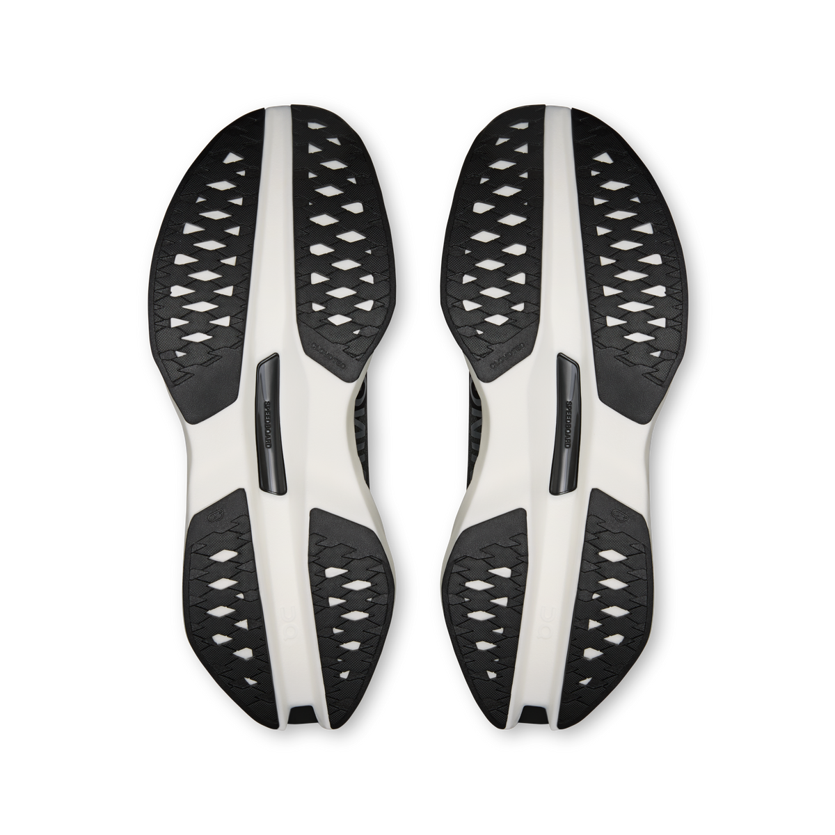 On Cloudboom Max men's shoe outsoles, black traction pods on white plates