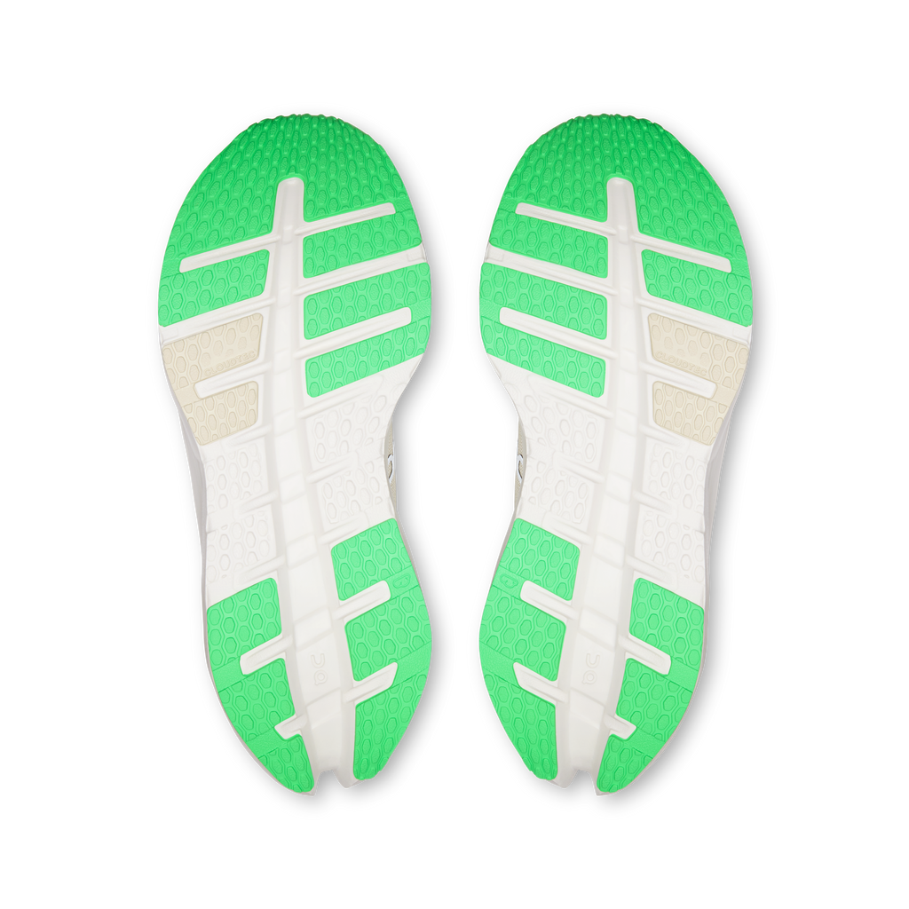 Pair of shoe outsoles with green traction pods and white crossbar tread