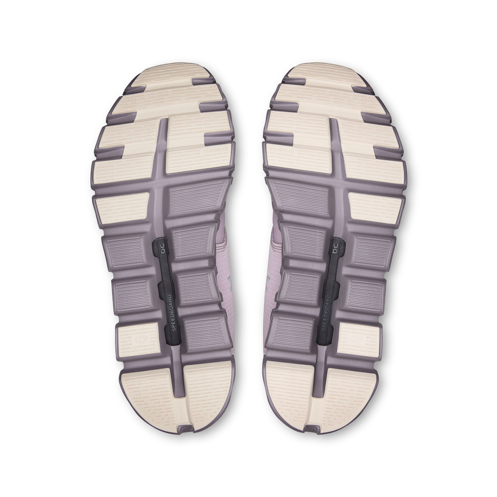 Outsoles of mauve running shoes with tread pattern and grip pods