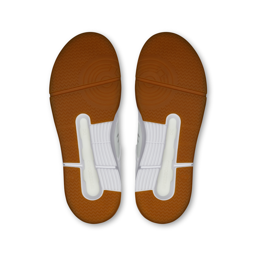 On women's sneaker outsoles in gum brown with tread and white heel pods