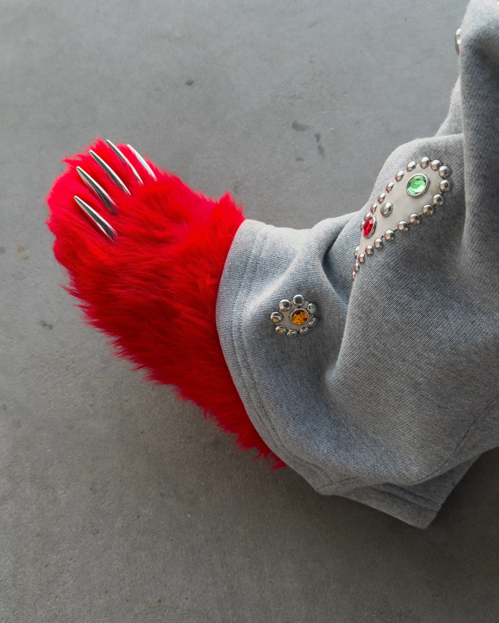 Red fuzzy bear claw mules with silver claw tips at the open toe