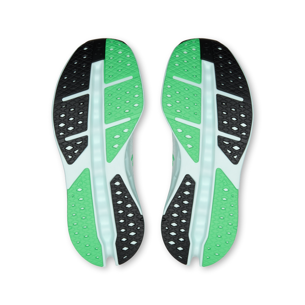 Shoe outsole view with green tread pods and black traction sections