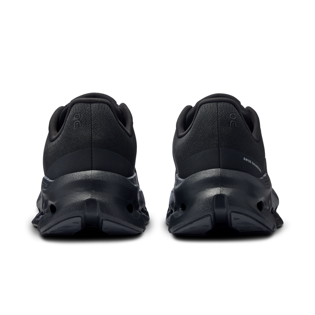 Women's black running shoes, heel view with cushioned back and outsole pods