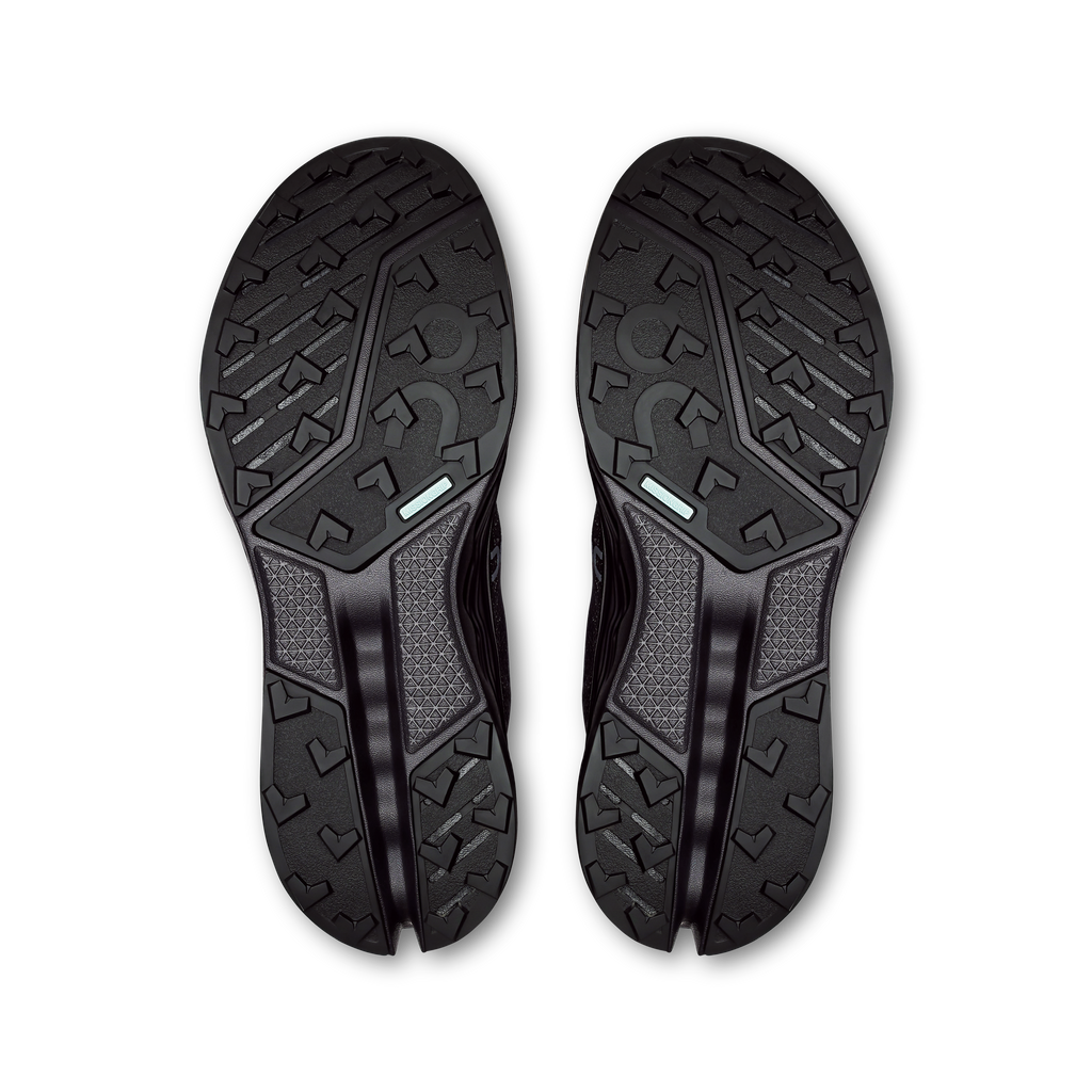 Pair of black waterproof trail shoe outsoles with rugged tread and grippy lugs
