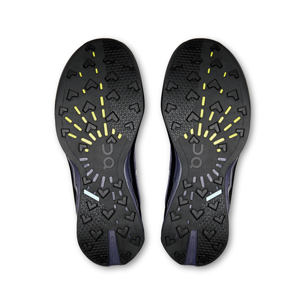 Shoe outsoles with black tread, yellow traction accents, and On branding