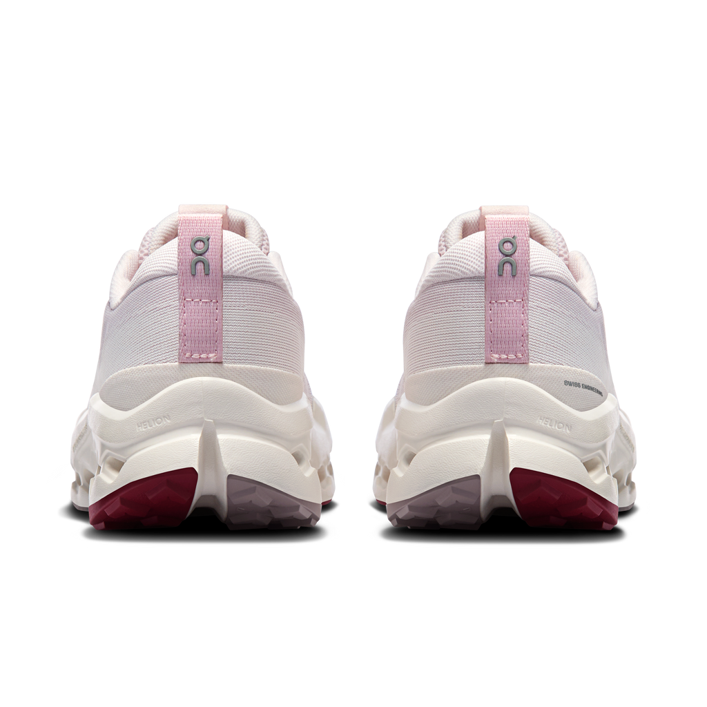Back view of light pink trail running shoes with heel pull tab and cushioned sole
