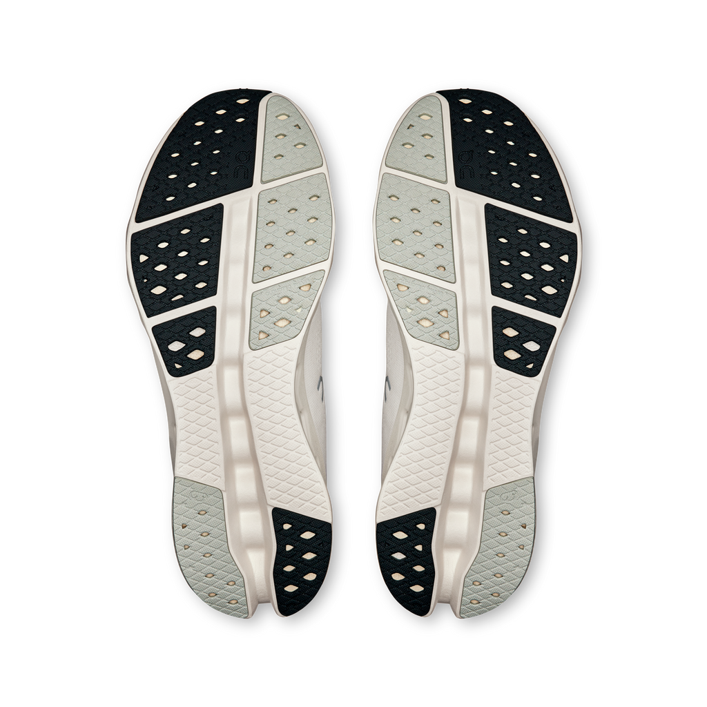 Pair of shoe outsoles with dark traction pods and textured gray/ivory tread