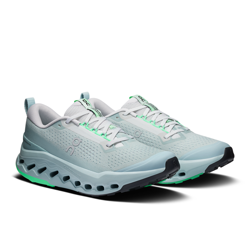 On women's trail running shoes, side view, light blue upper with green tread detailing