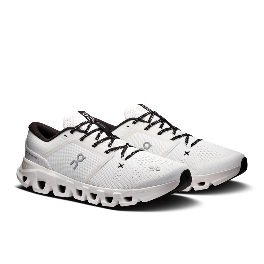 Pair of white running shoes with black laces and thick cushioned outsole