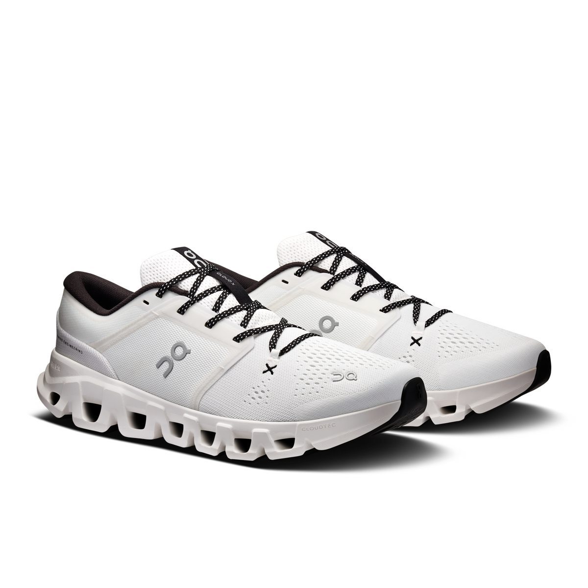 Pair of white running shoes with black laces and thick cushioned outsole