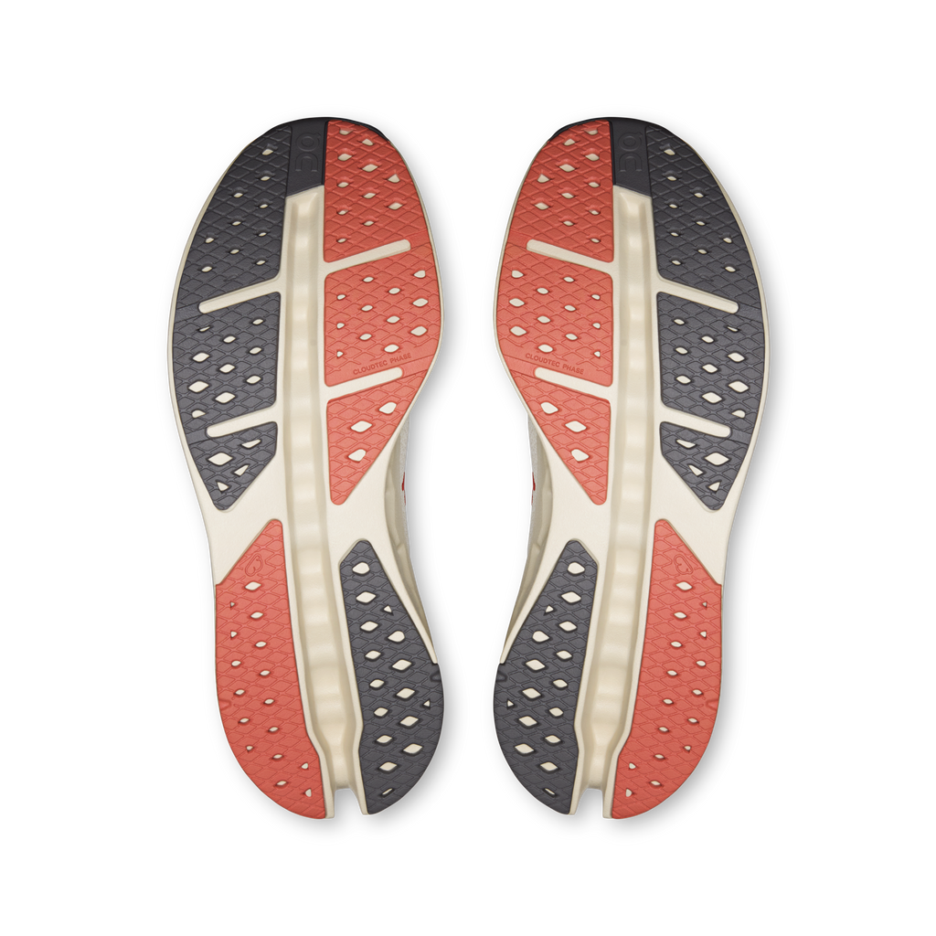 On Cloudsurfer Max shoe outsoles showing red and gray traction patterns on both soles
