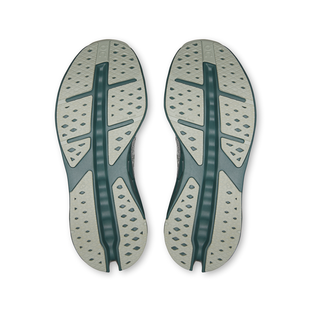 Shoe outsole view with textured tread and teal center support stripe