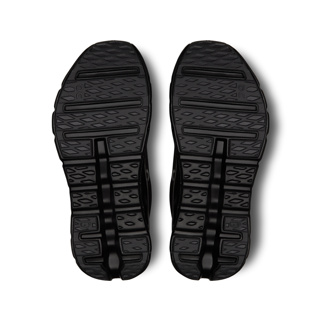 Black outsole tread pattern on women's running shoes, bottom view