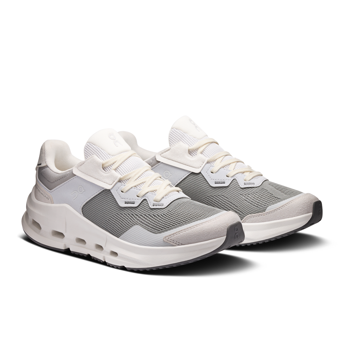Pair of women's running shoes with gray uppers, white midsoles, and lace-up straps