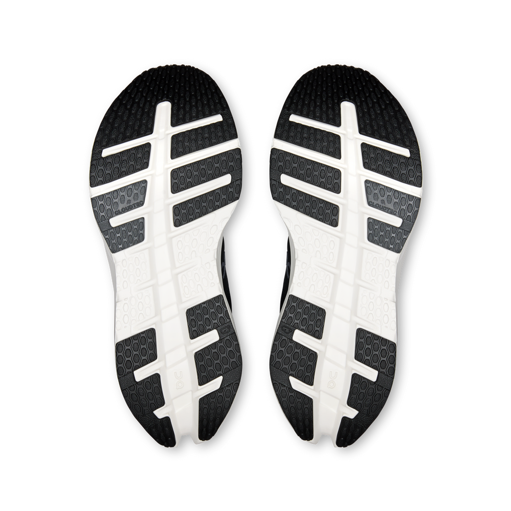 Pair of black outsoles with white cross tread and grid pattern traction.