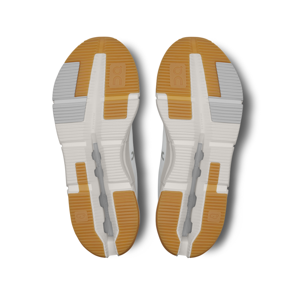 Pair of shoe outsoles, white with orange grip areas and segmented traction grooves