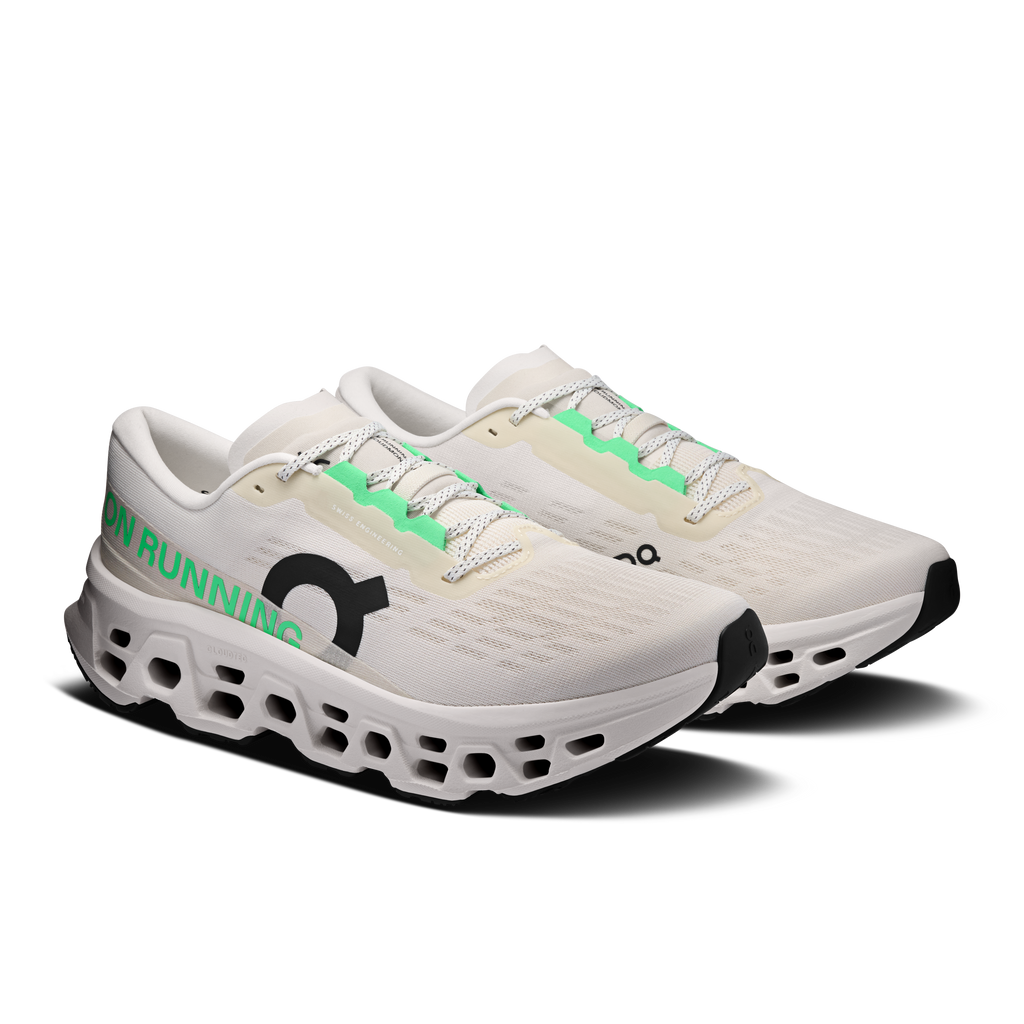 Ivory wide running shoe with green lace accents and patterned knit upper