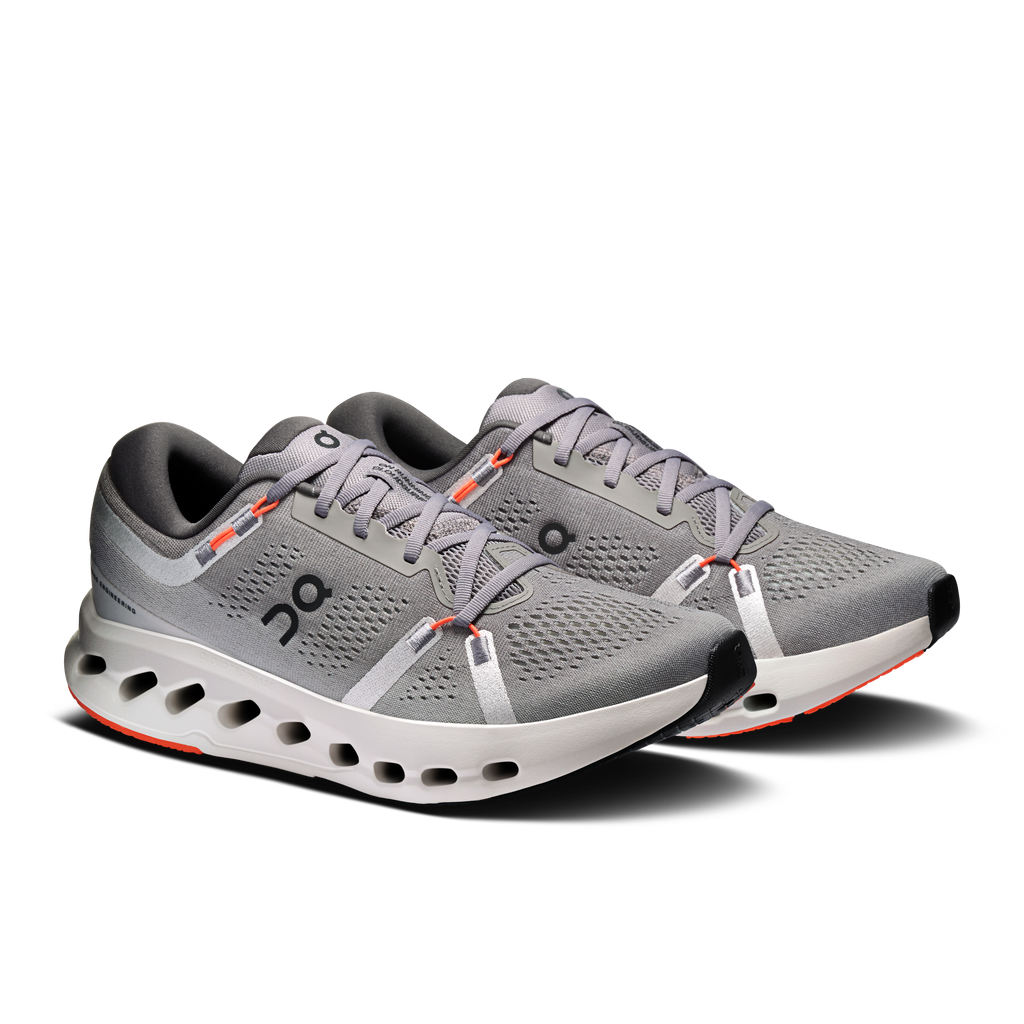 Men's running shoes, gray upper with perforations, white rocker sole, orange trim.