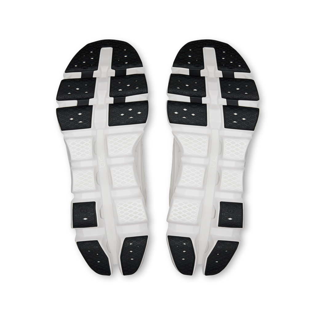 Shoe outsole view: white rubber sole with black grip pads and central support bridge