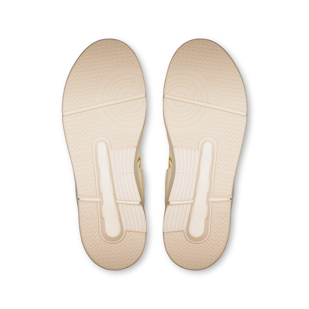 Pair of ivory shoe outsoles with textured tread and side traction grooves