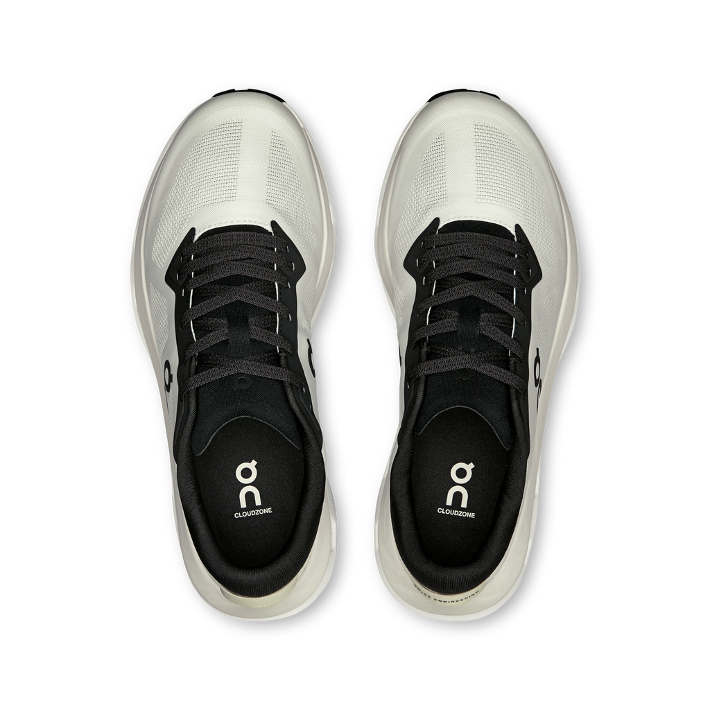 Pair of white lace-up shoes with black tongue and eyelets
