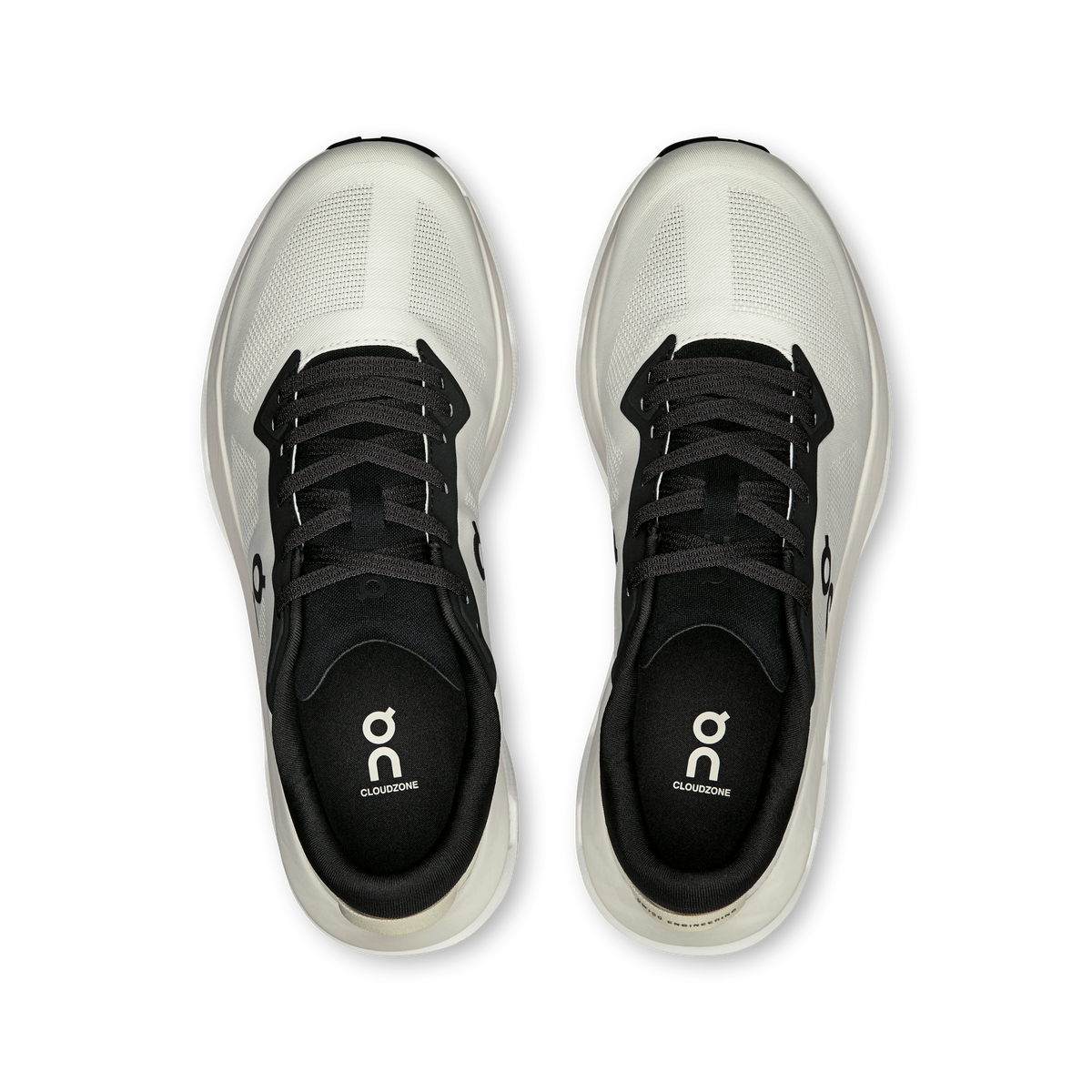Pair of white lace-up shoes with black tongue and eyelets