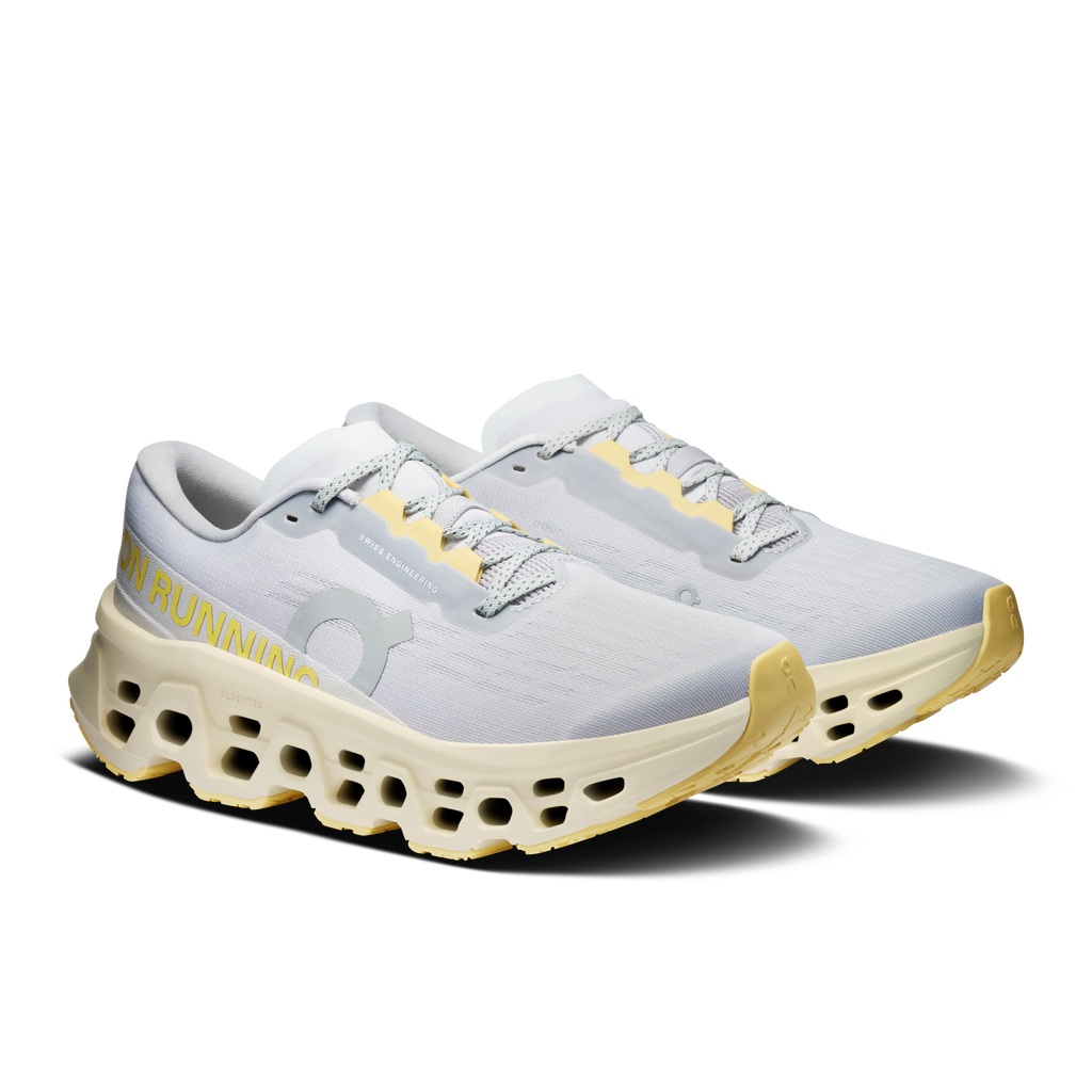 Light gray lace-up running shoe with yellow outsole pods and On logo