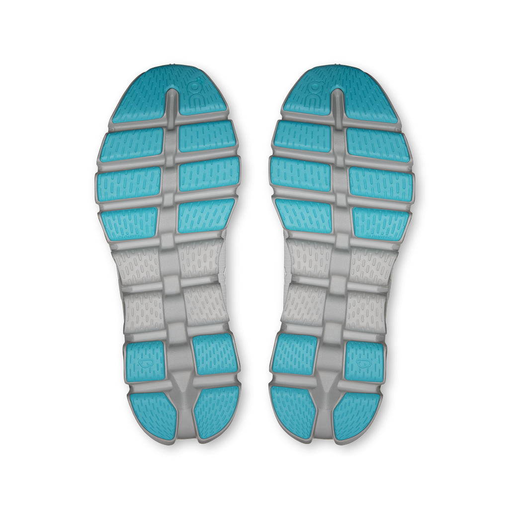 Shoe outsoles pair with turquoise traction pods on gray rubber tread