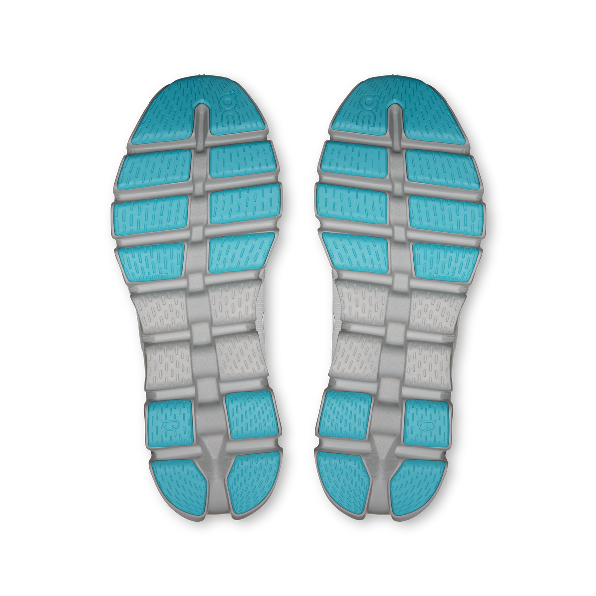 Shoe outsoles pair with turquoise traction pods on gray rubber tread